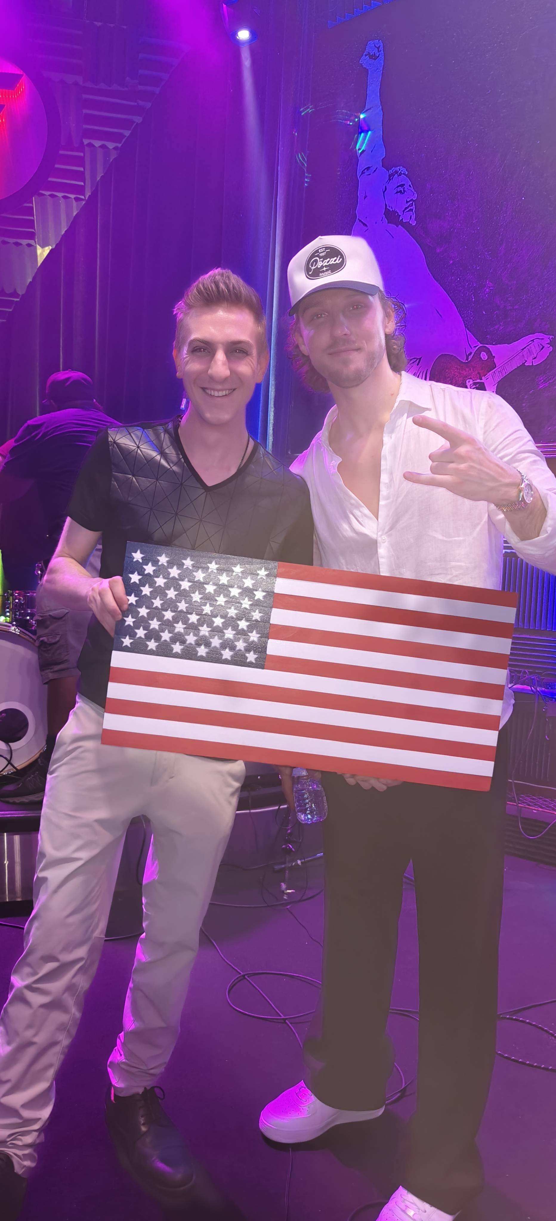 Two performers posing with American flag on stage at Even Flow