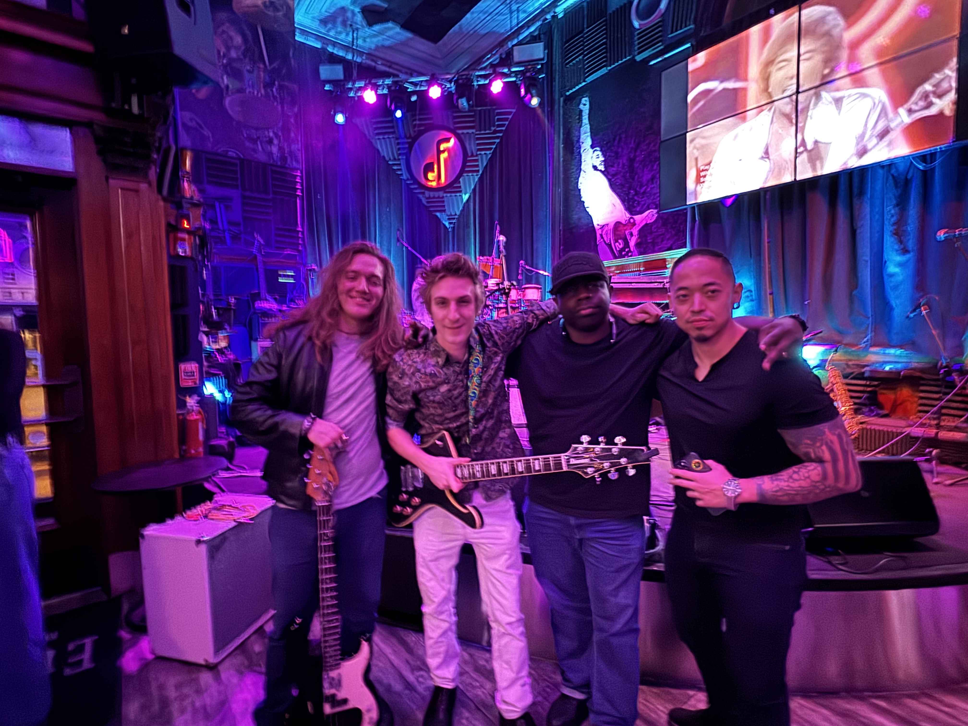 Band with guitars in professional music venue with stage screens