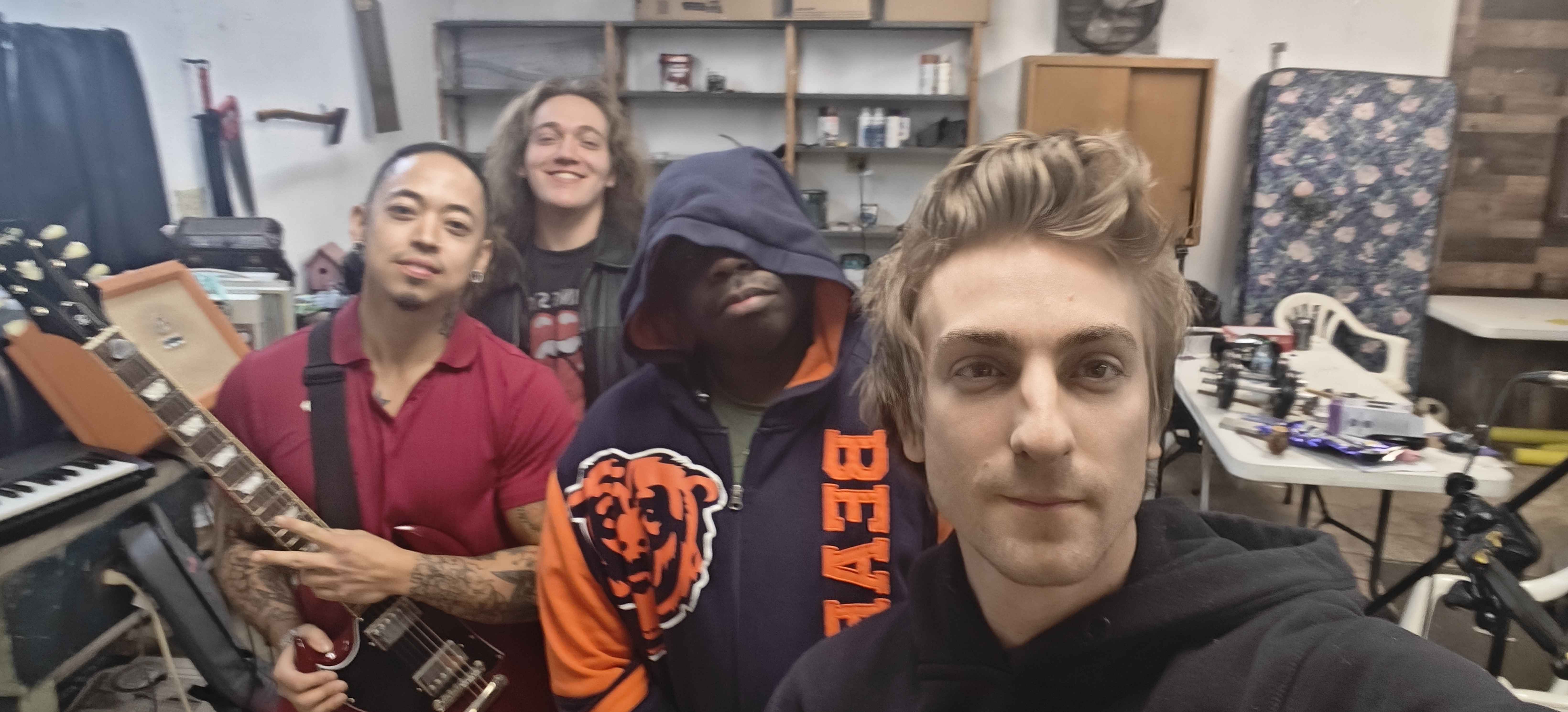 Group selfie in practice studio with instruments