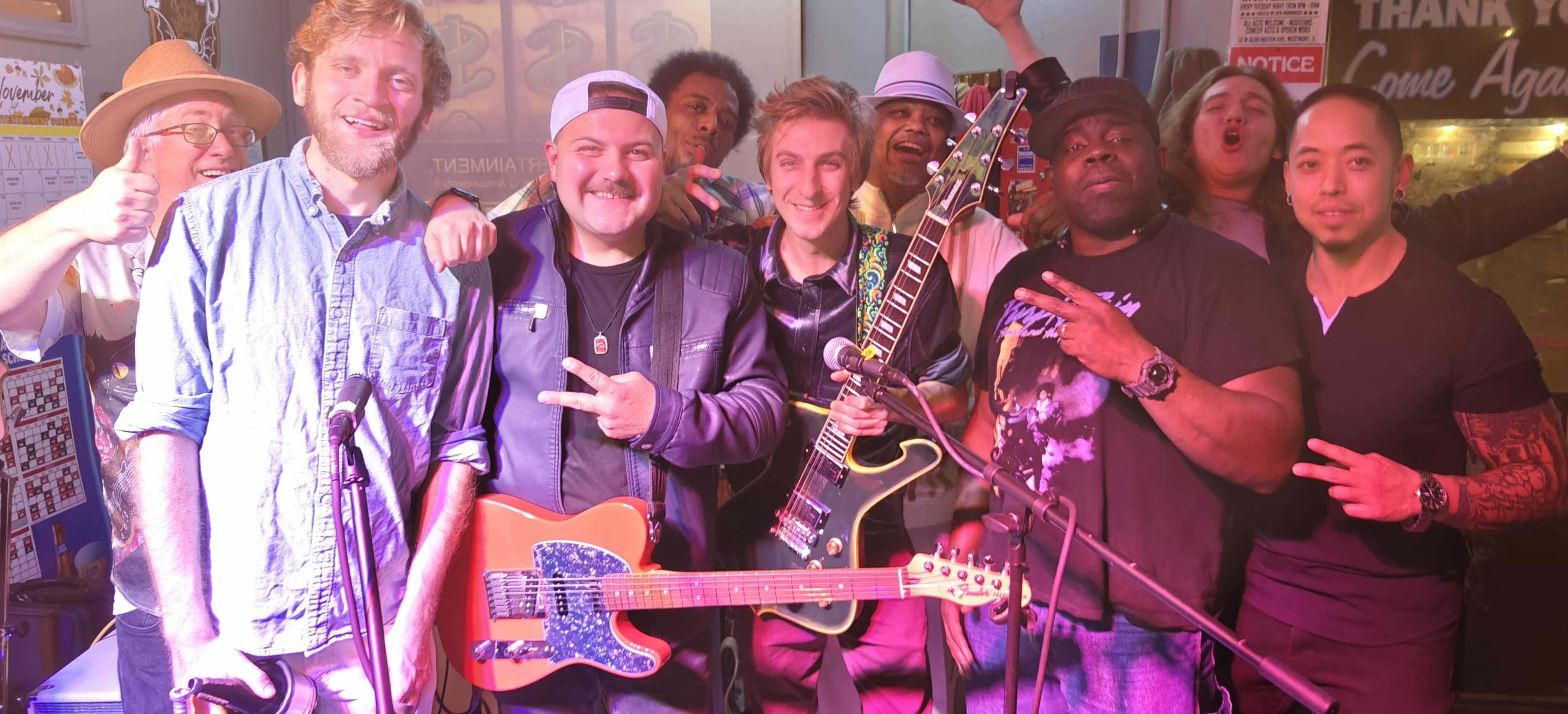 Large group photo with musicians and friends at music venue